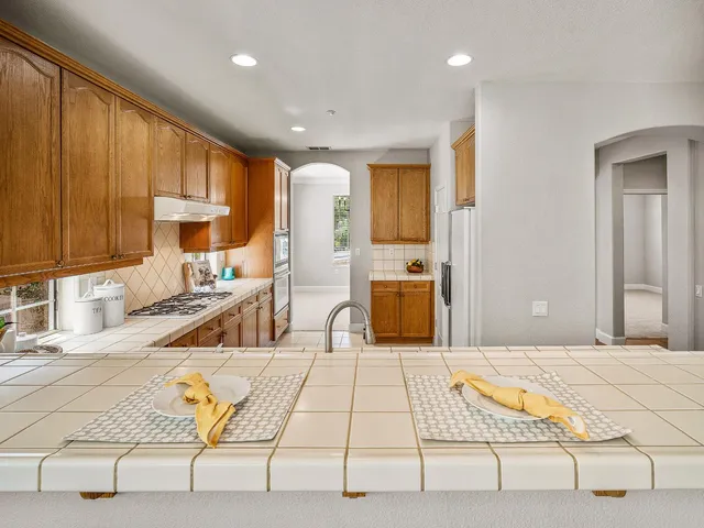 a large kitchen with stainless steel appliances kitchen island granite countertop a sink and cabinets