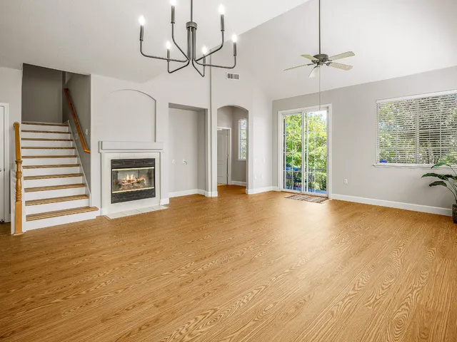 a view of empty room with fireplace and wooden floor