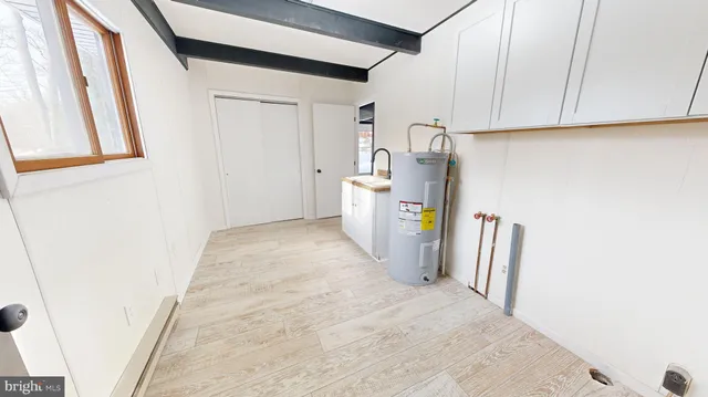 a view of a storage and utility room with refrigerator