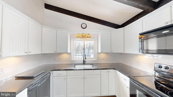 a kitchen with stainless steel appliances granite countertop a sink a stove and cabinets