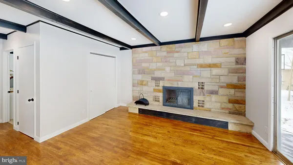 a view of an empty room with a fireplace and a window