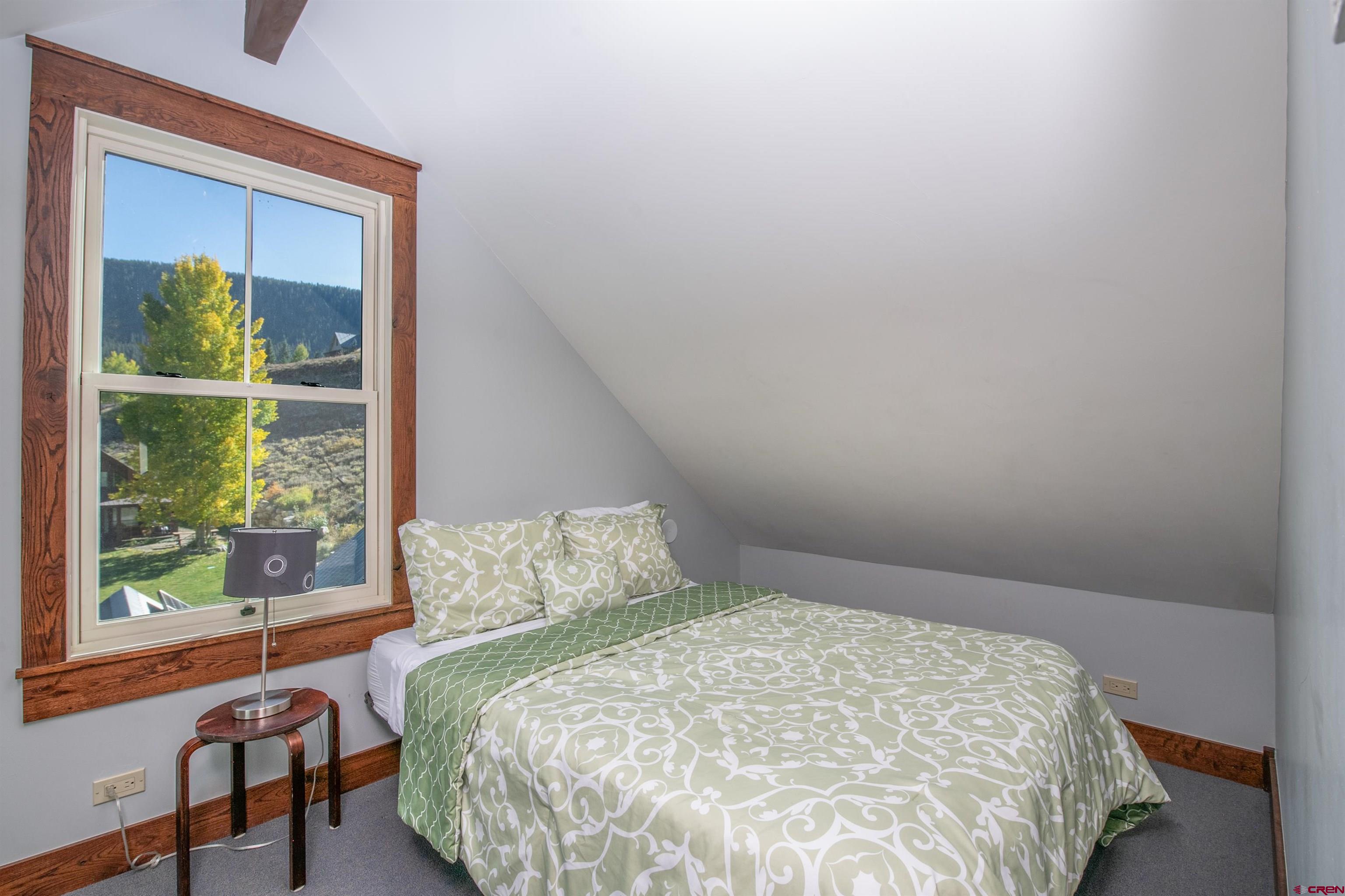 1 Teocalli Avenue Crested Butte, CO 81224 - Photo 22 of 35 a large bed sitting in a bedroom next to a window