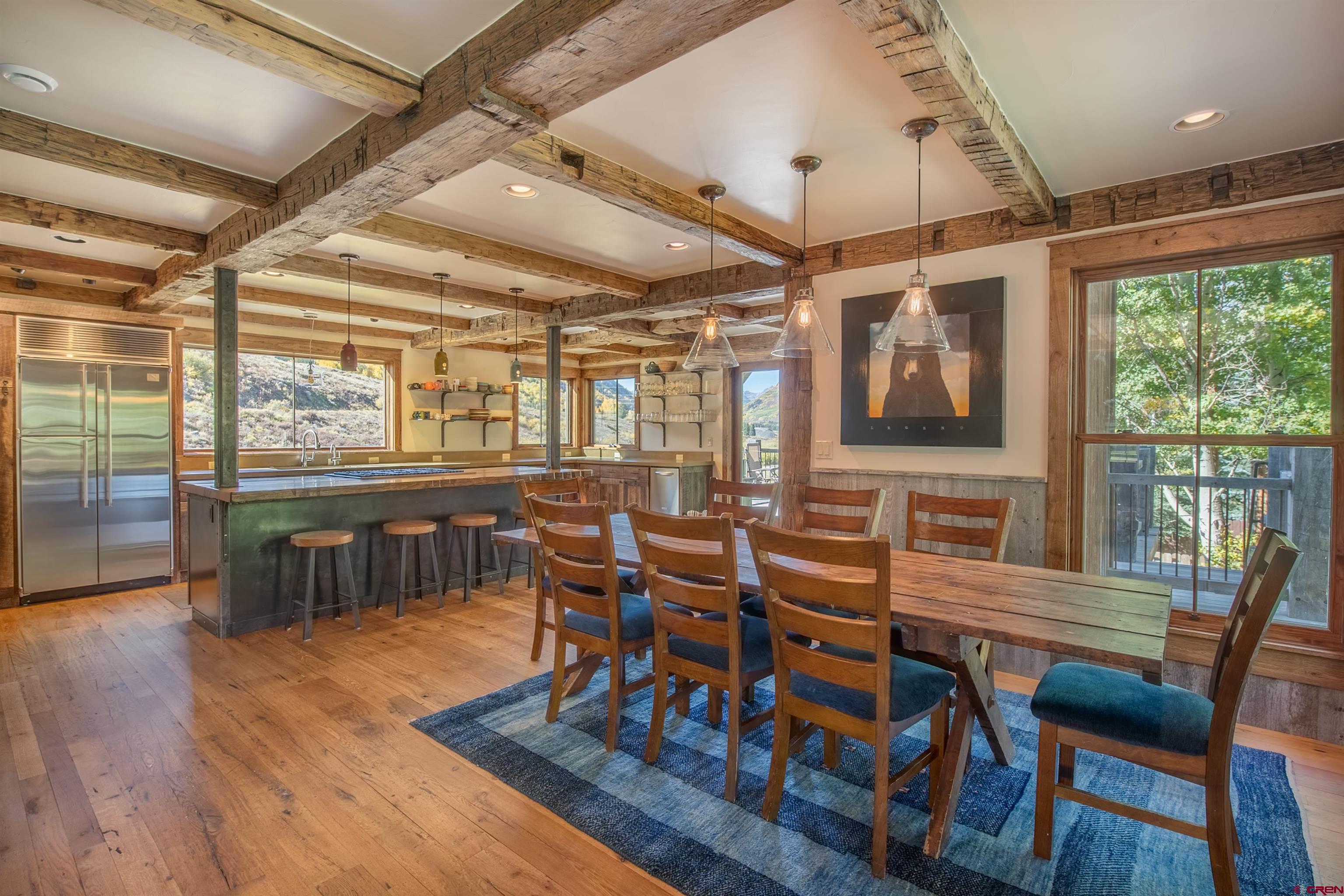 1 Teocalli Avenue Crested Butte, CO 81224 - Photo 9 of 35 a dining room with wooden floor a glass table and chairs