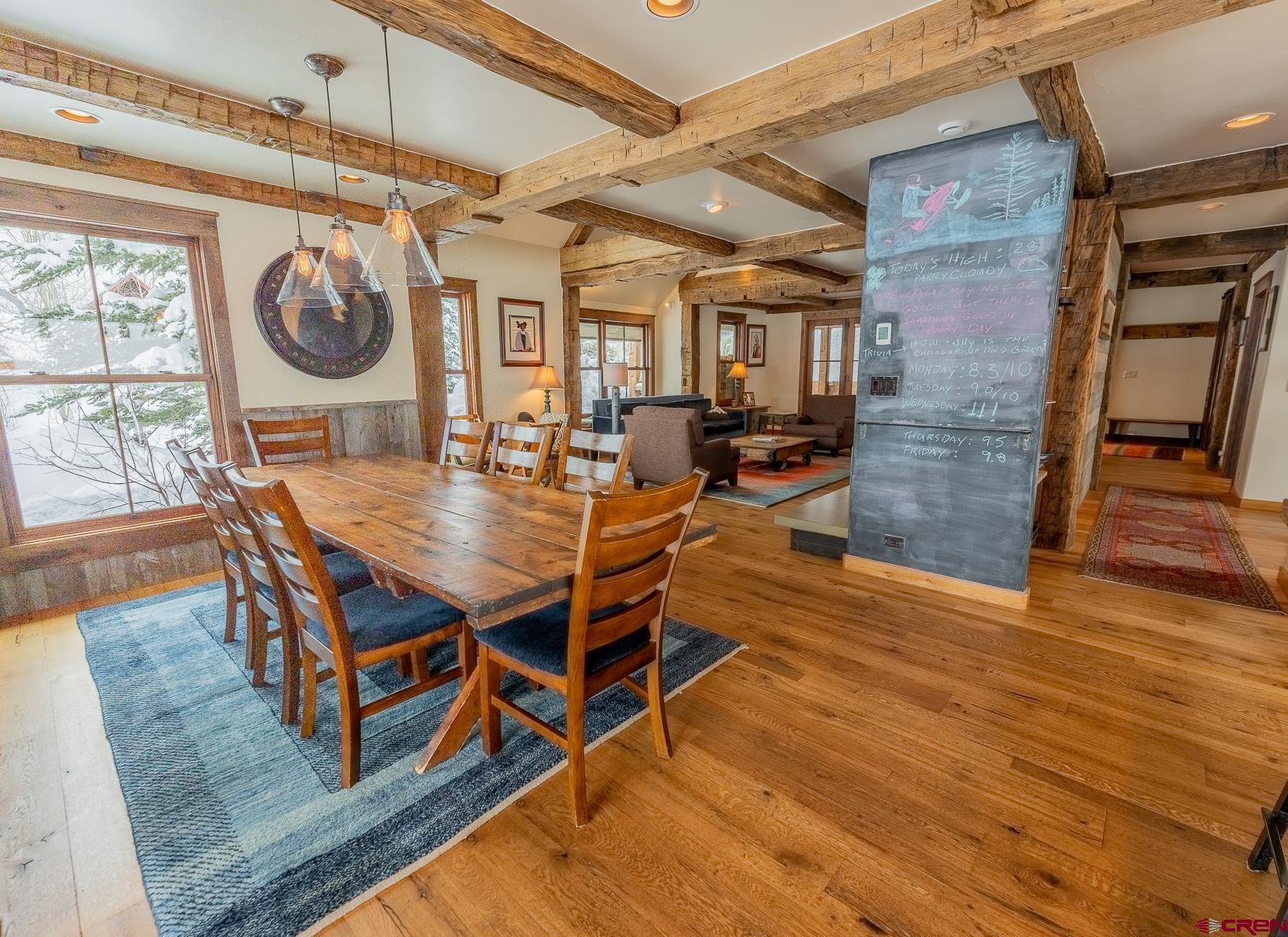 1 Teocalli Avenue Crested Butte, CO 81224 - Photo 10 of 35 a dining room with wooden floor a chandelier a wooden table and chairs
