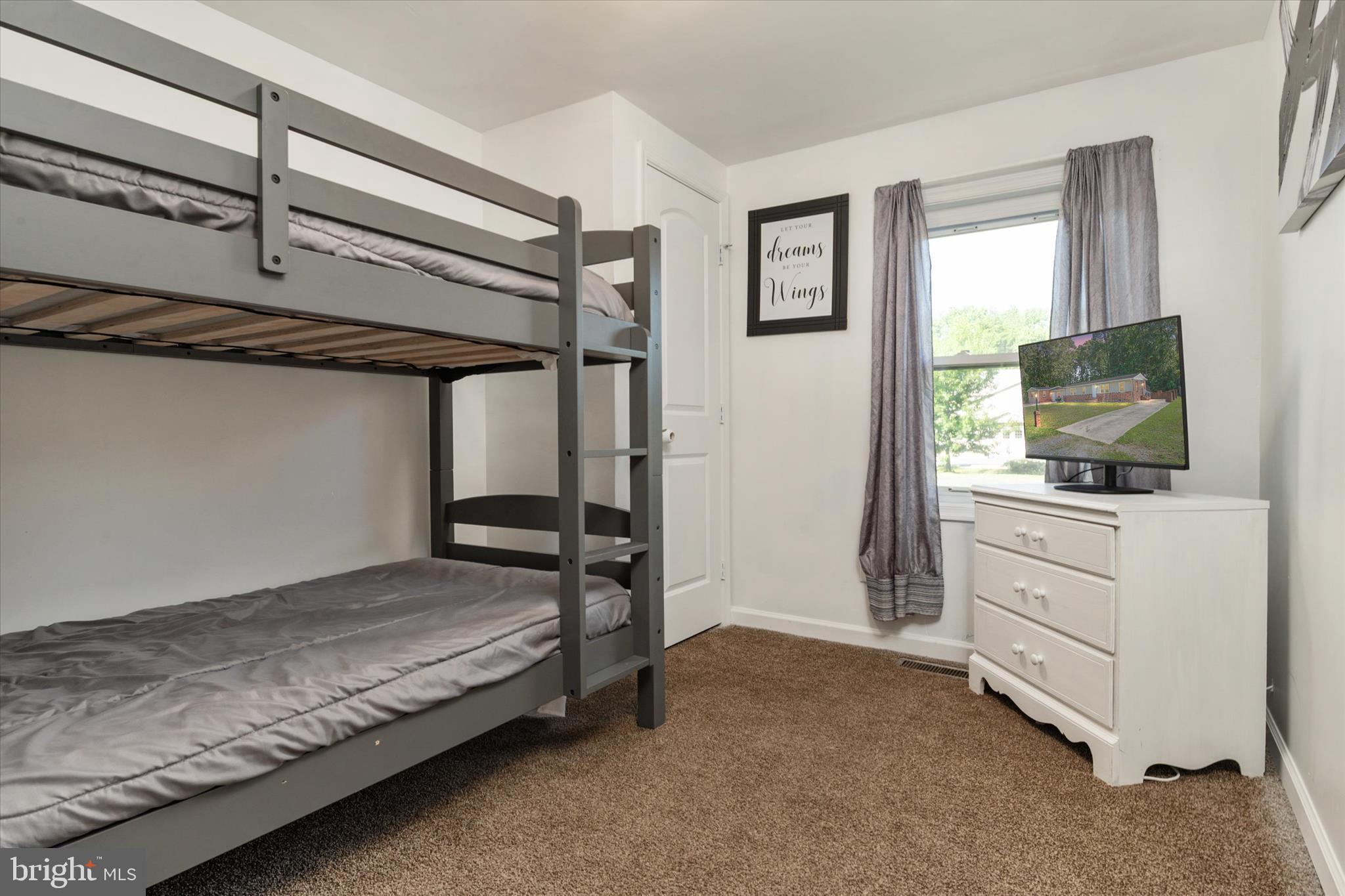 108 Wilson Road Grasonville, MD 21658 - Photo 15 of 38 a bedroom with a bed and flat screen tv