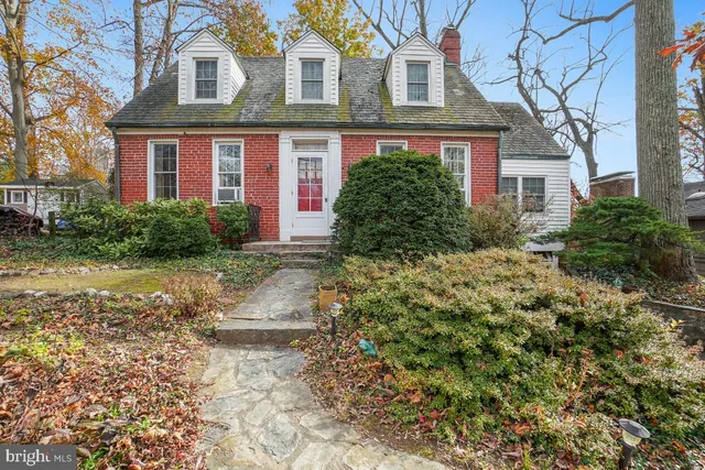 a view of a brick house with a yard and plants