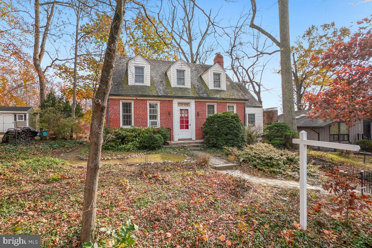 6540 Wiscasset Road Bethesda, MD 20816 - Photo 4 of 33 a view of a brick house next to a yard with large trees