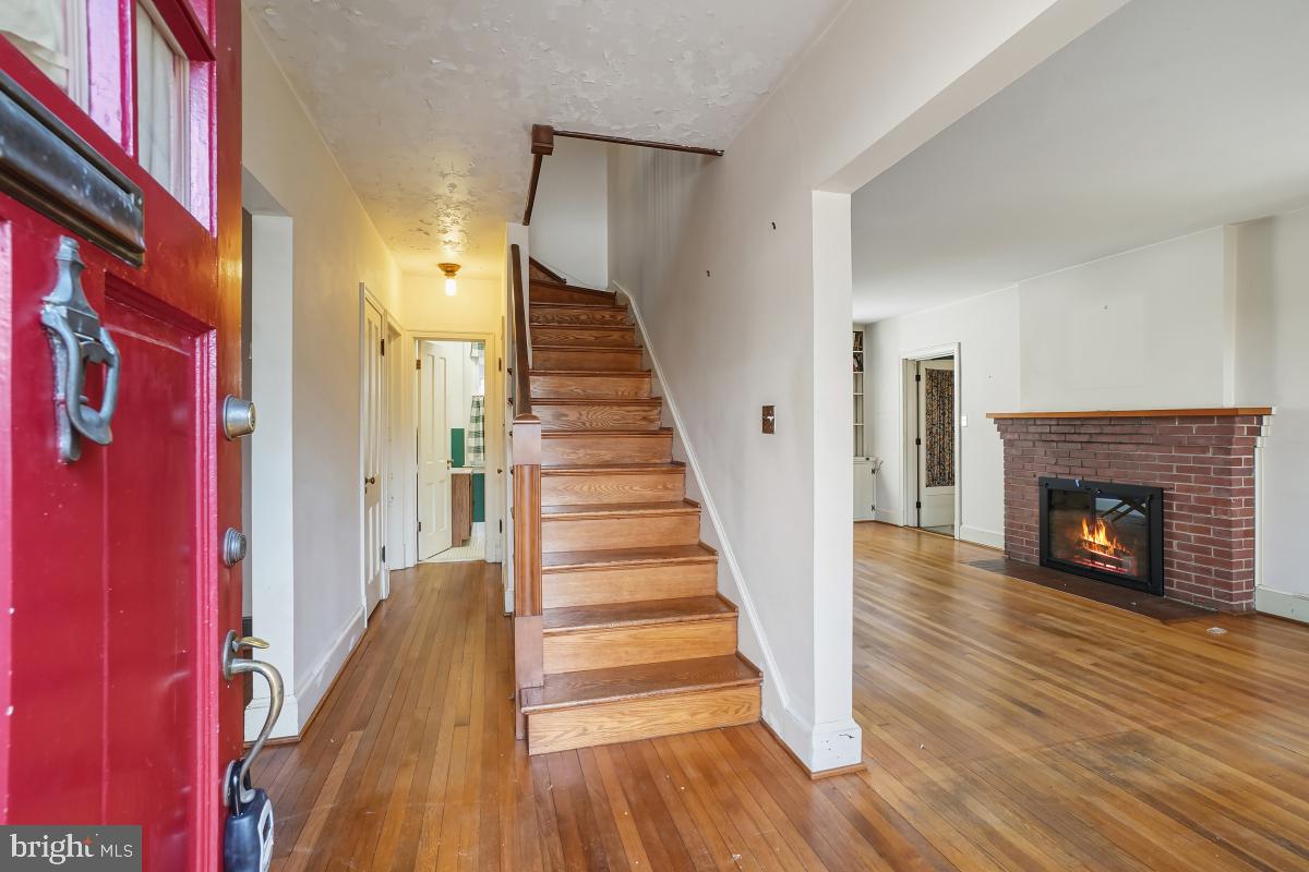 6540 Wiscasset Road Bethesda, MD 20816 - Photo 7 of 33 a view of a hallway with wooden floor and a fireplace