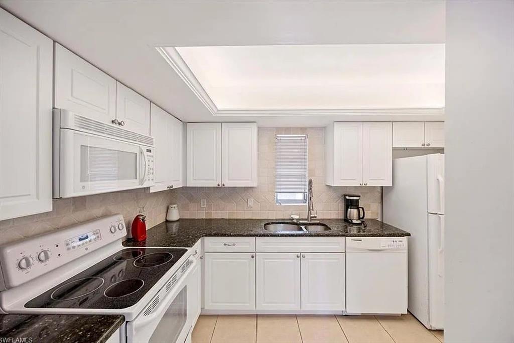 209 Bobolink Way, Unit A Naples, FL 34105 - Photo 11 of 23 a kitchen with stainless steel appliances granite countertop a sink stove and white cabinets