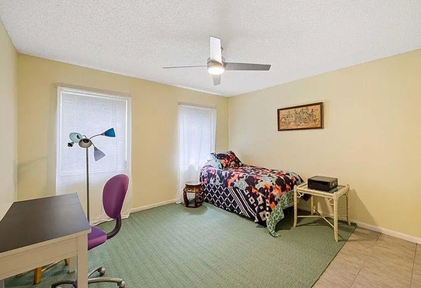 209 Bobolink Way, Unit A Naples, FL 34105 - Photo 15 of 23 a bedroom with bed and a chandelier