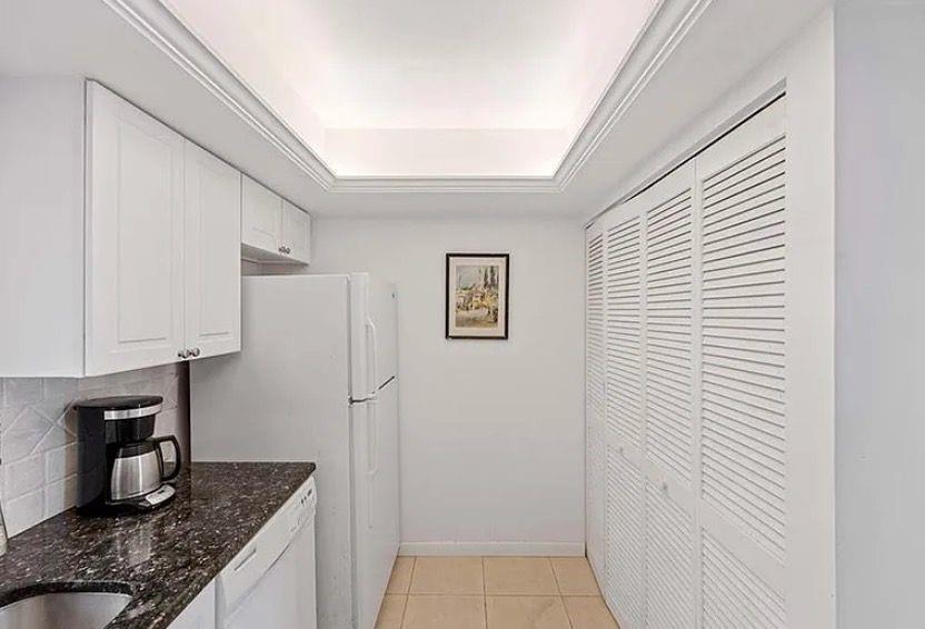 209 Bobolink Way, Unit A Naples, FL 34105 - Photo 10 of 23 a kitchen with a refrigerator and cabinets