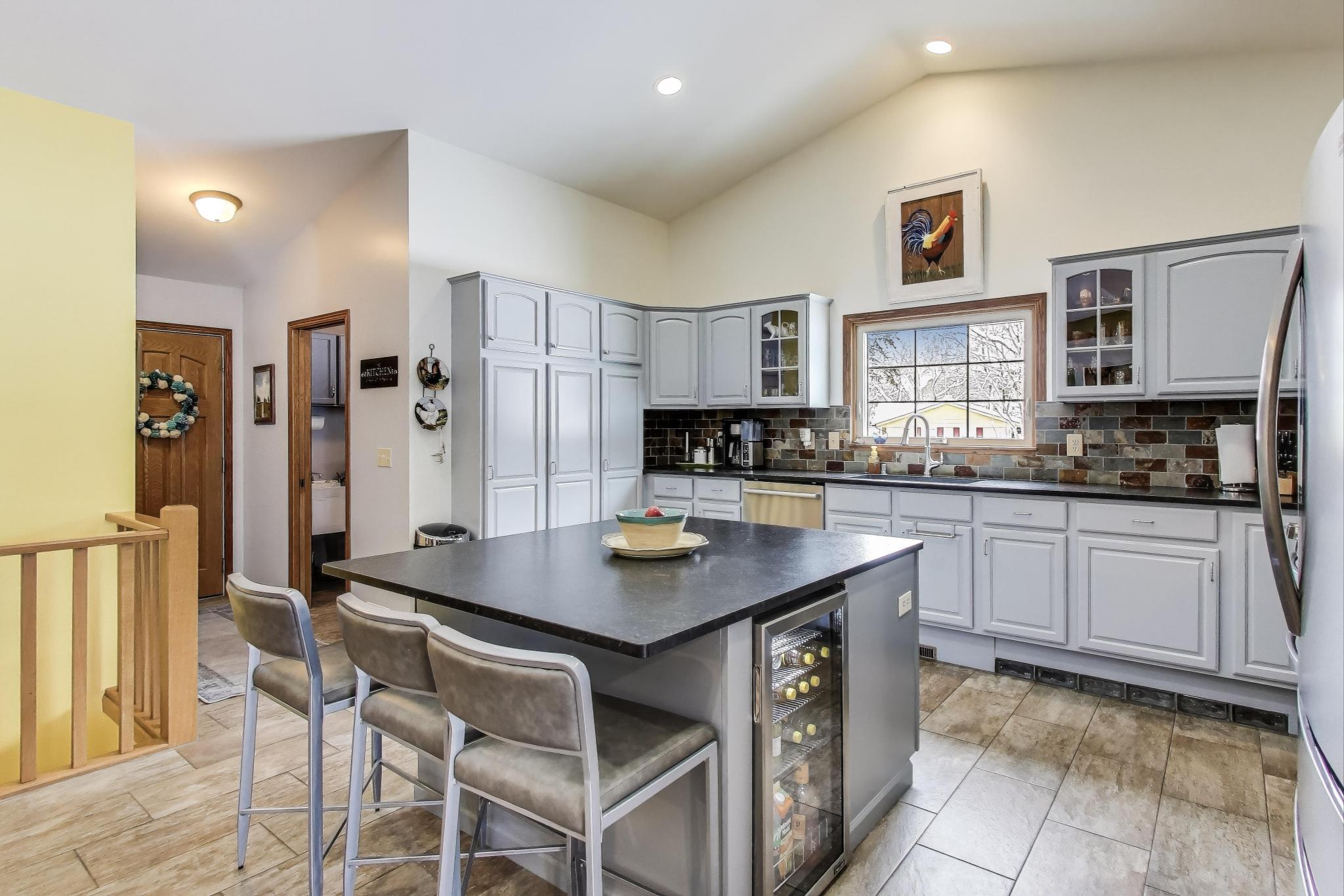 W312S8869 Cherokee Pass Mukwonago, WI 53149 - Photo 17 of 75 Kitchen island with mini beverage fridge.