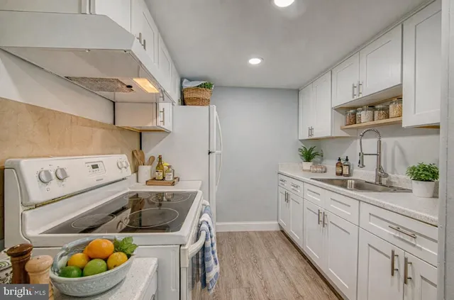 a kitchen with a sink a stove and cabinets