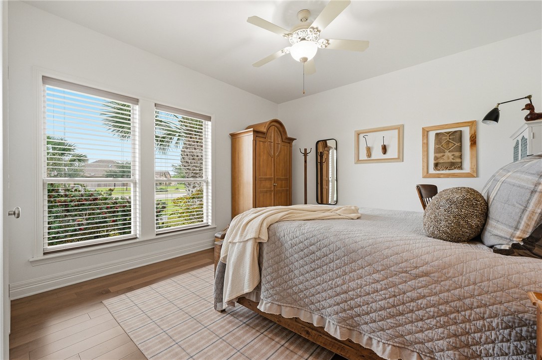 8710 KIng Ranch Drive Corpus Christi, TX 78414 - Photo 22 of 38 a bedroom with a large bed and a chandelier