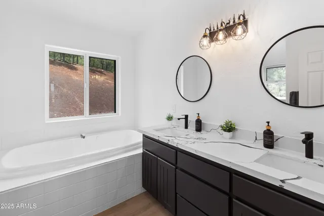 a bathroom with a granite countertop sink mirror and bathtub