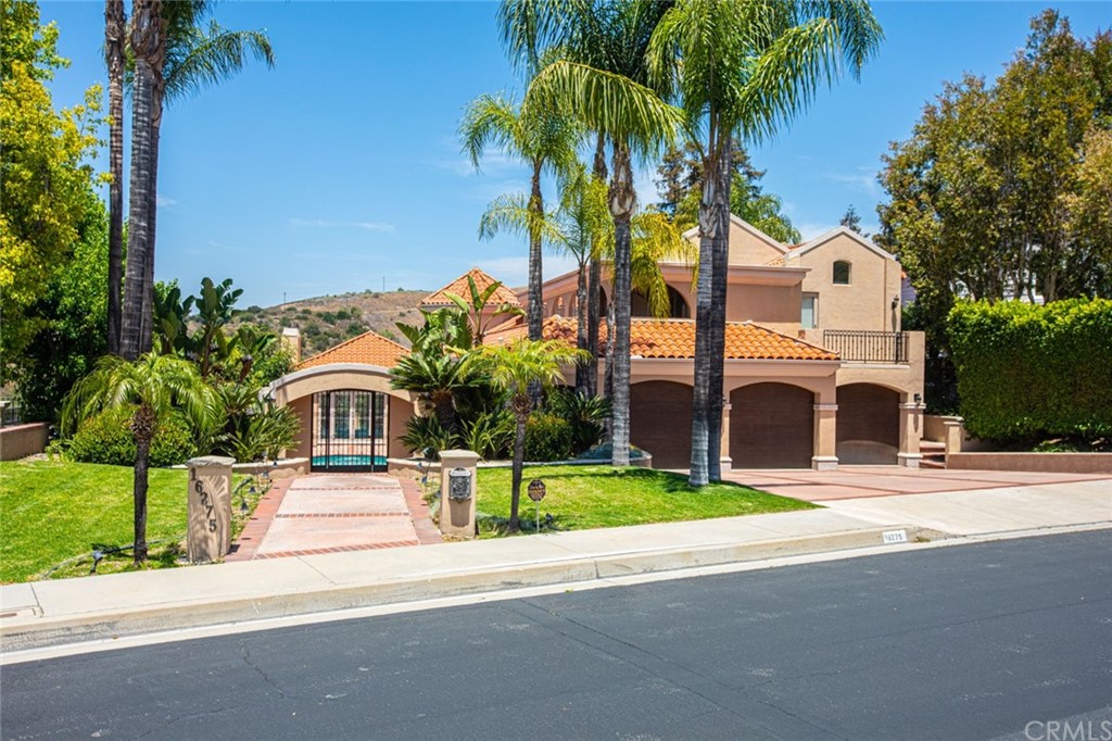 a front view of multiple houses with yard and green space