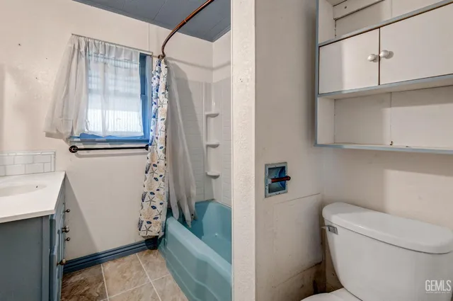 a bathroom with a granite countertop sink a toilet and shower