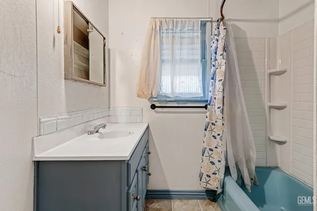 a bathroom with a sink a mirror a shower and a mirror