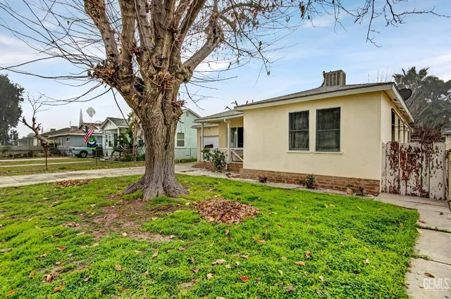 a view of a house with a tree in the yard