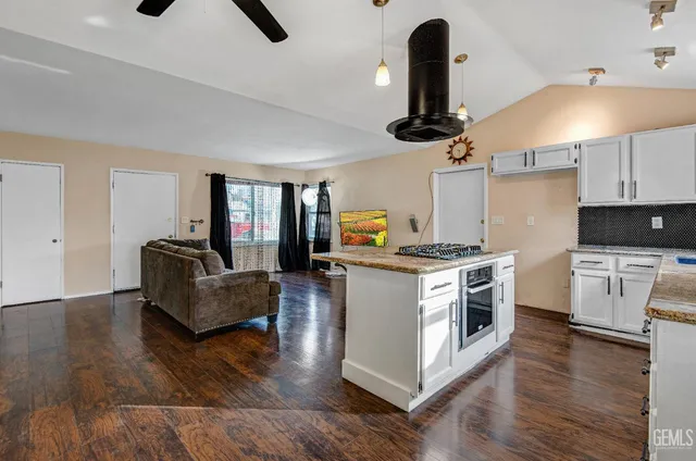 a kitchen with a stove cabinets and wooden floor