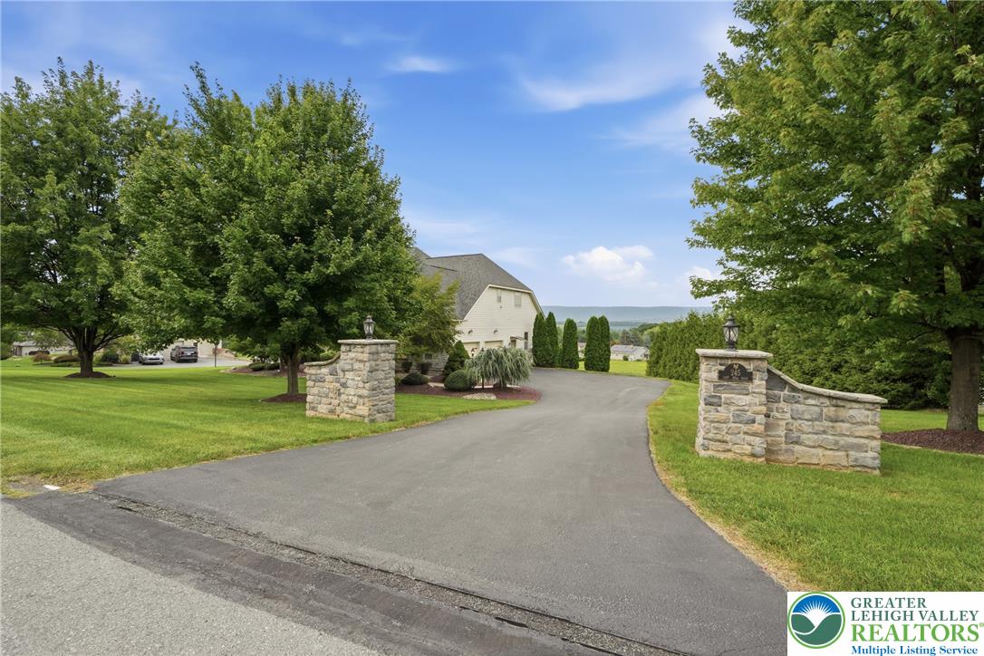 245 East Dell Road Bath, PA 18014 - Photo 95 of 99 A long paved driveway leads to a classic home framed by mature trees and stone entry pillars.