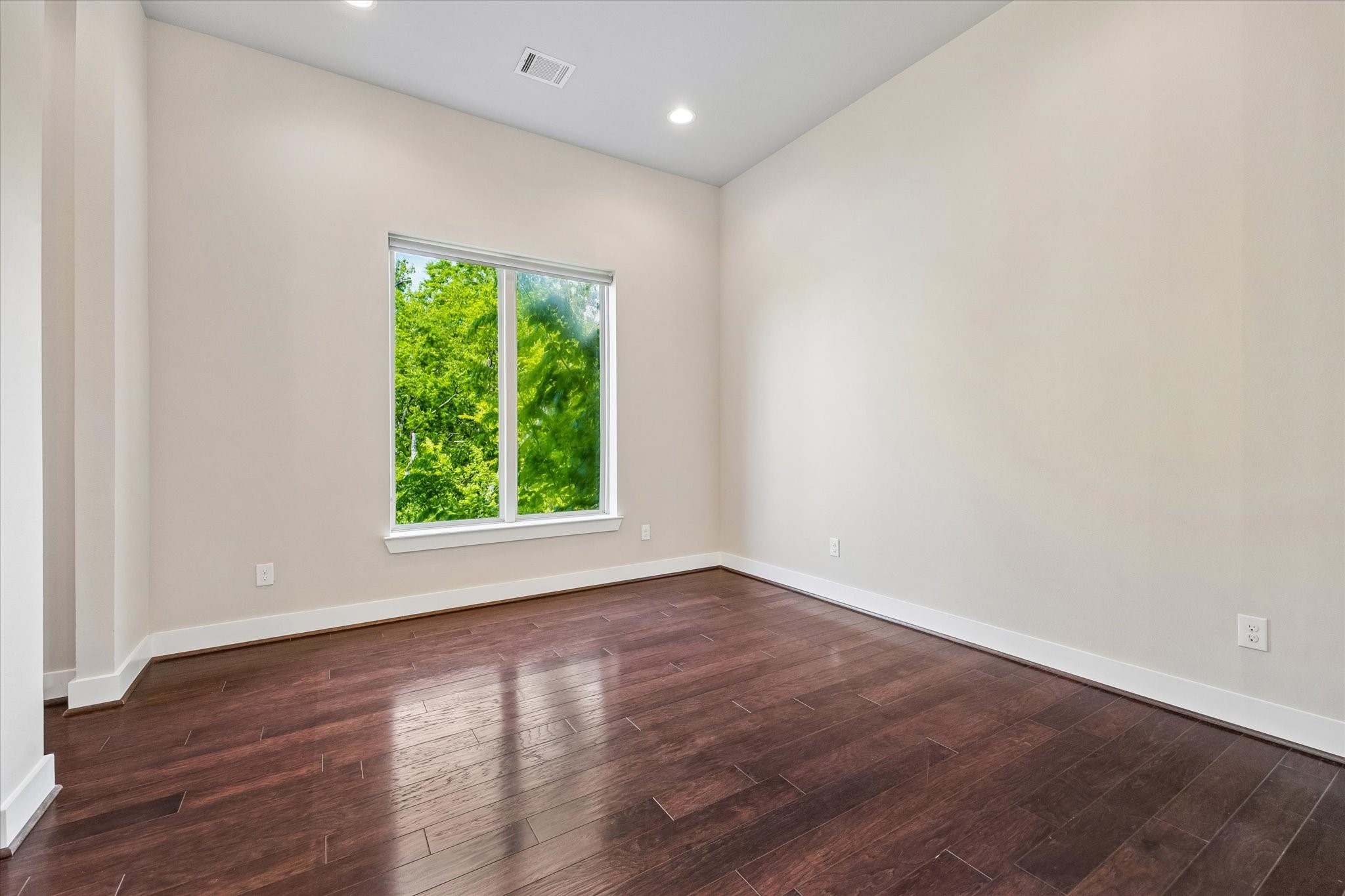 2103 Patterson Street Houston, TX 77007 - Photo 13 of 27 a view of an empty room with wooden floor and a window