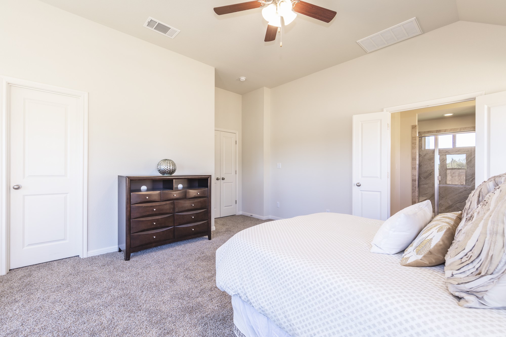 2725 Hopi Path Leander, TX 78641 - Photo 28 of 30 A tranquil bedroom retreat features a soaring vaulted ceiling and convenient primary bathroom access.