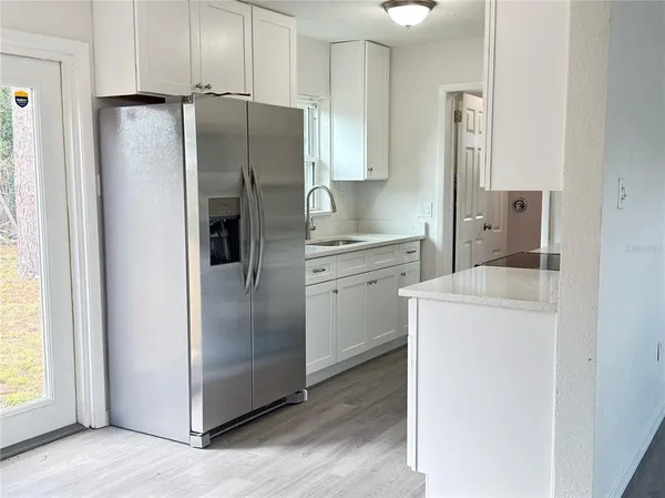 a kitchen with a refrigerator sink and cabinets
