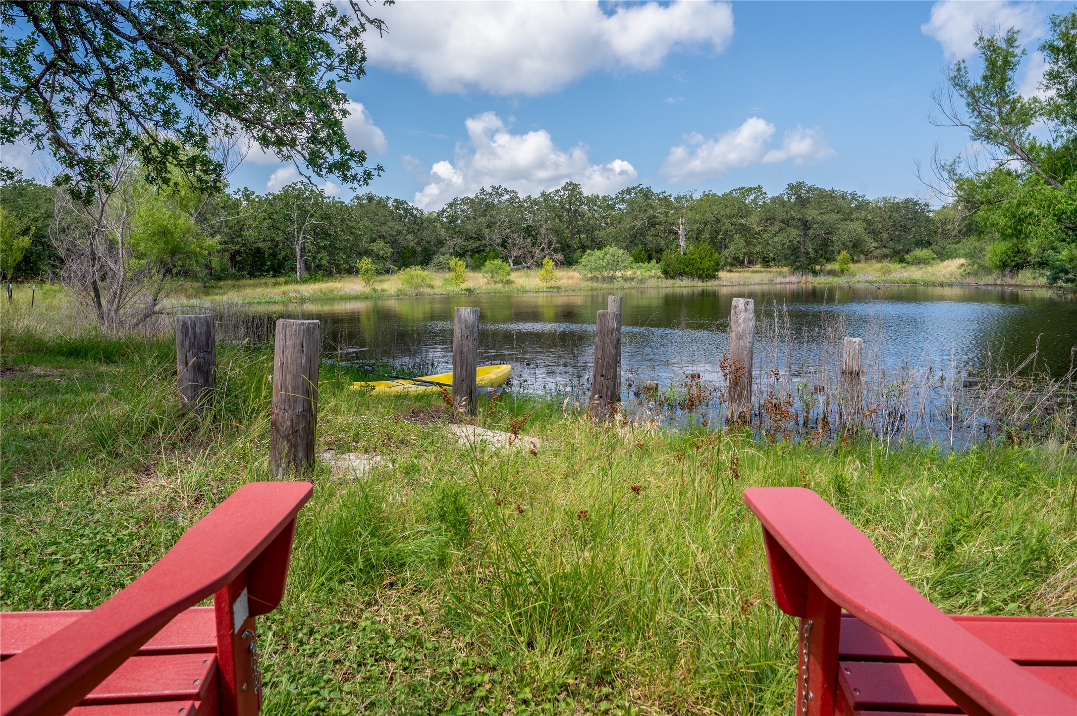 270 Dry Creek Road Manor, TX 78653 - Photo 1 of 40 Relax in Adirondack chairs while enjoying tranquil pond views framed by a lush treeline.