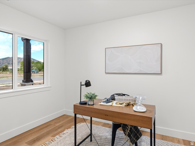 1267 West 2350 South Perry, UT 84302 - Photo 33 of 35 Light-filled room featuring a large window, wood-finish flooring, and crisp white walls