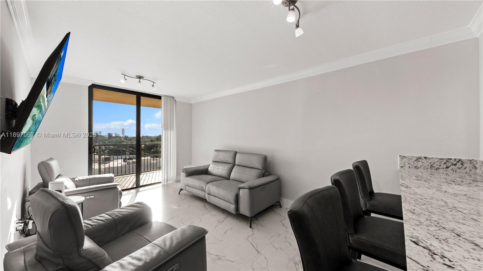 1690 Southwest 27th Avenue, Unit 603 Miami, FL 33145 - Photo 12 of 41 a living room with furniture rug and a flat screen tv