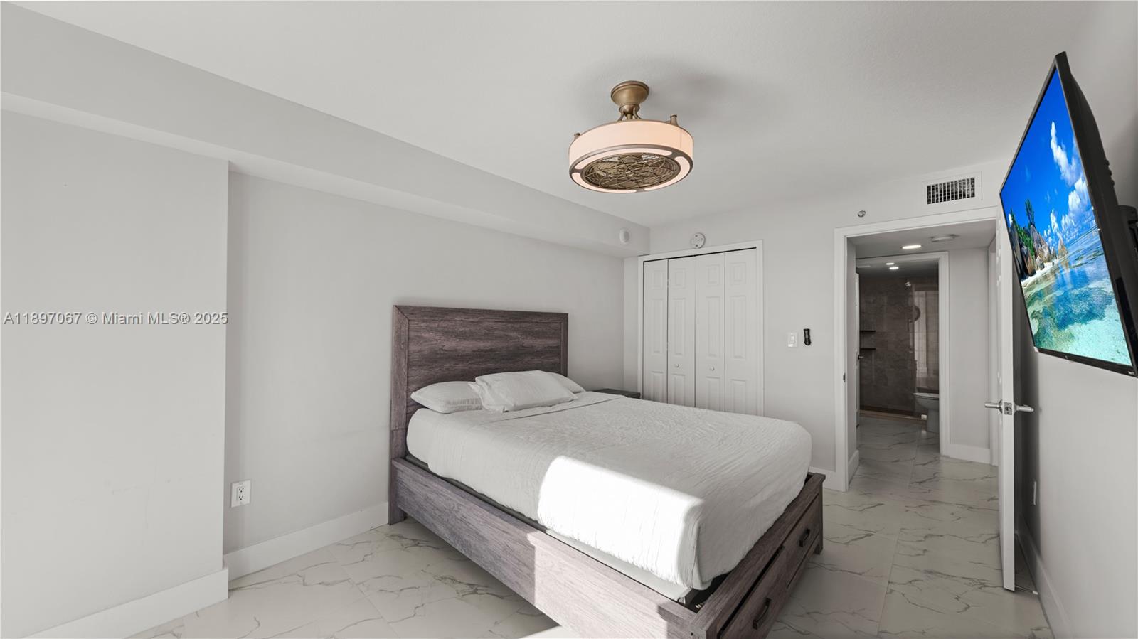 1690 Southwest 27th Avenue, Unit 603 Miami, FL 33145 - Photo 17 of 41 a bedroom with a bed and a chandelier