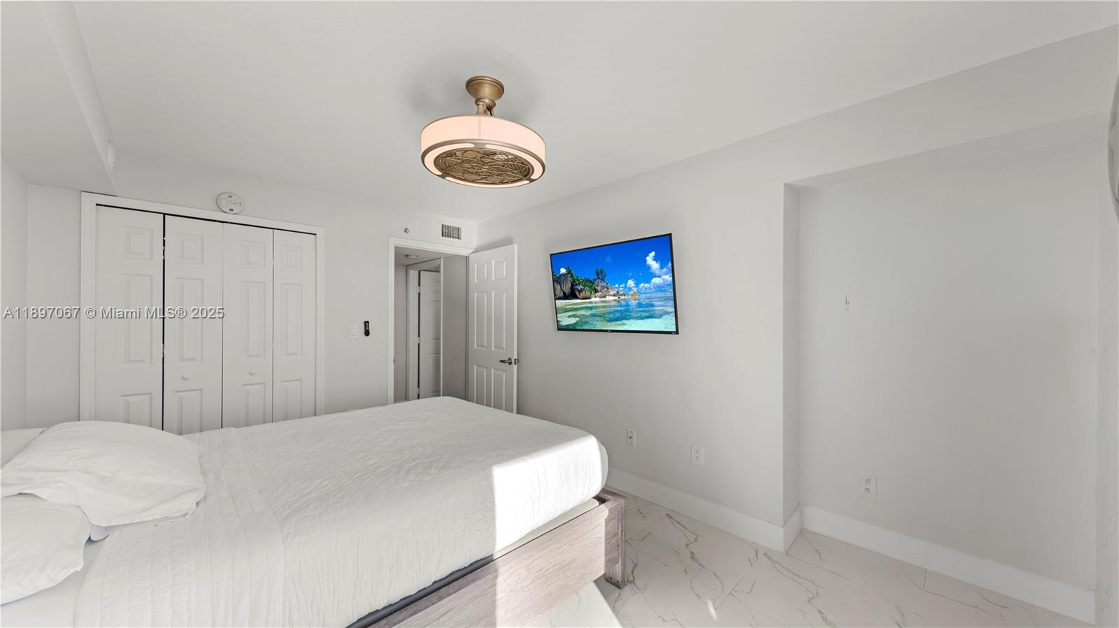 1690 Southwest 27th Avenue, Unit 603 Miami, FL 33145 - Photo 19 of 41 a bedroom with a bed and a chandelier