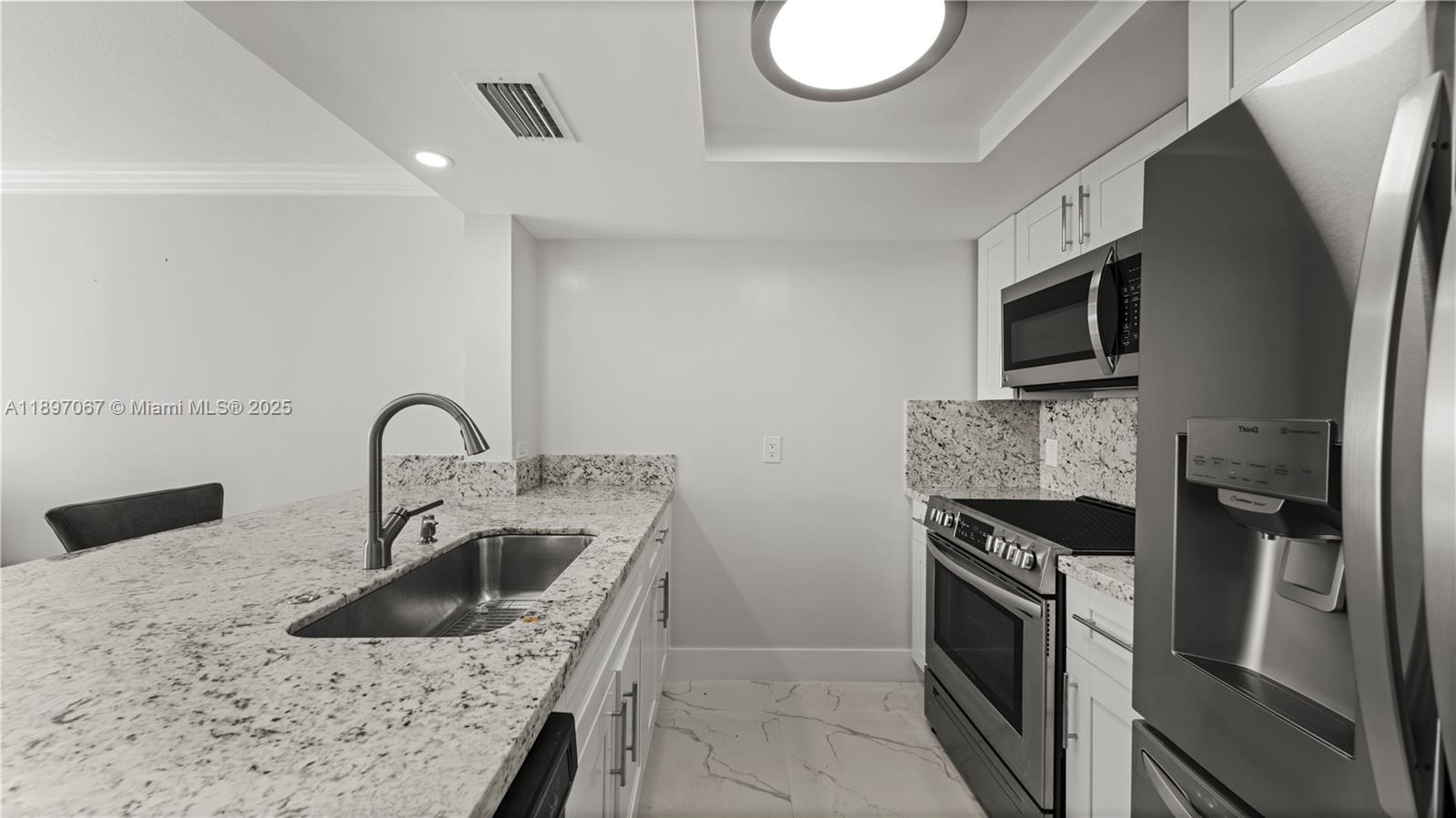 1690 Southwest 27th Avenue, Unit 603 Miami, FL 33145 - Photo 6 of 41 a kitchen with stainless steel appliances granite countertop a sink stove and refrigerator