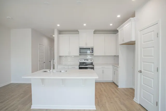 a kitchen with stainless steel appliances white cabinets and a refrigerator