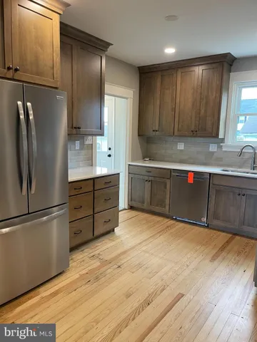 a kitchen with stainless steel appliances granite countertop a refrigerator and a sink