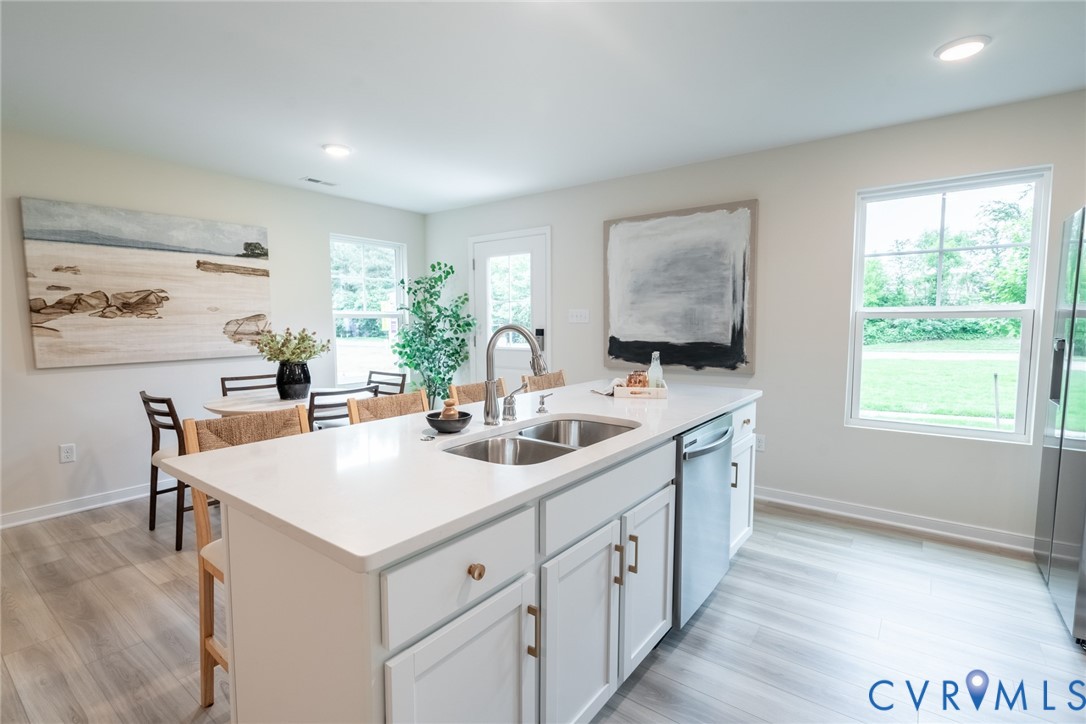 a kitchen with sink a window and chairs