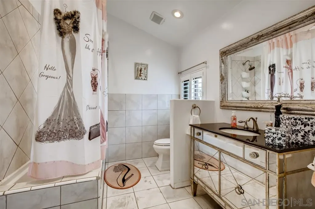 1913 Alga Road Carlsbad, CA 92009 - Photo 18 of 25 a bathroom with a granite countertop sink a toilet and a shower