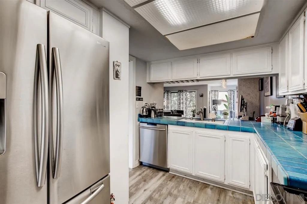 1913 Alga Road Carlsbad, CA 92009 - Photo 8 of 25 a kitchen with stainless steel appliances granite countertop a refrigerator a sink and white cabinets