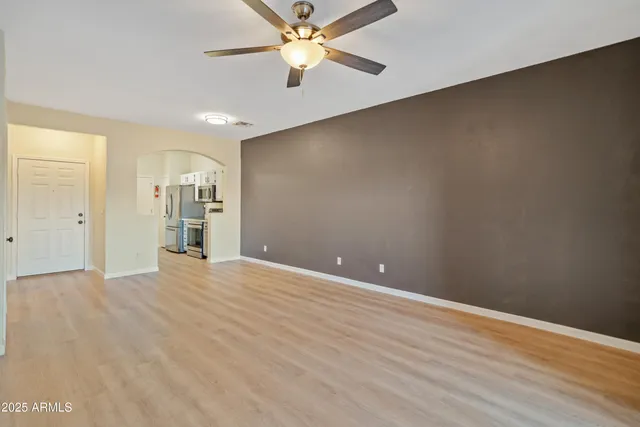 an empty room with closet and a ceiling fan