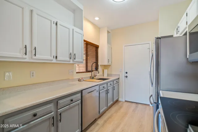 a kitchen with stainless steel appliances white cabinets and a refrigerator