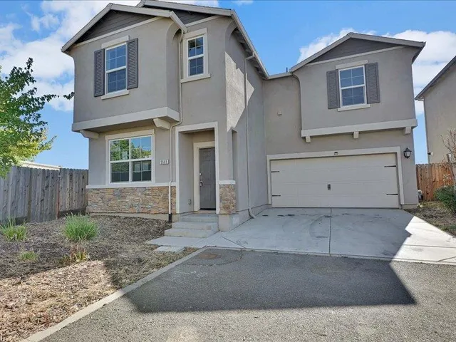 a view of a house with a yard and garage