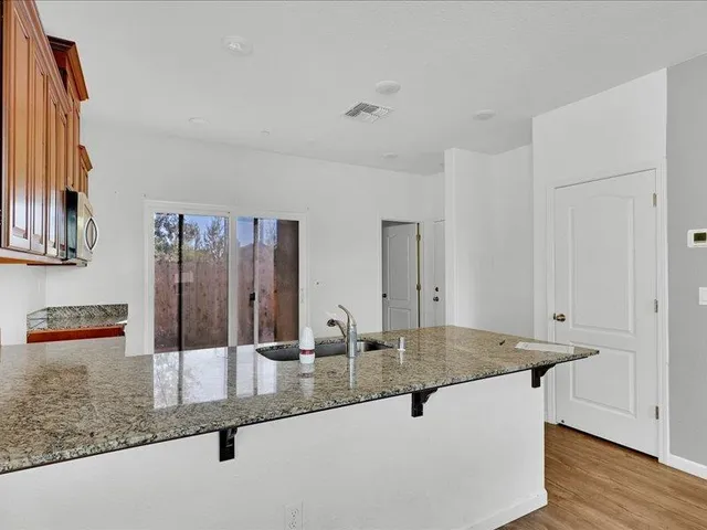 a kitchen with granite countertop a sink and cabinets