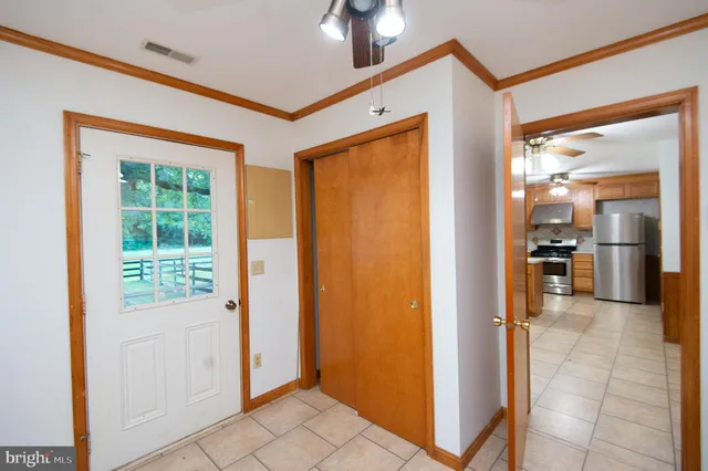 a view of an empty room with a window and a kitchen