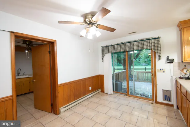 an empty room with a window and a fan