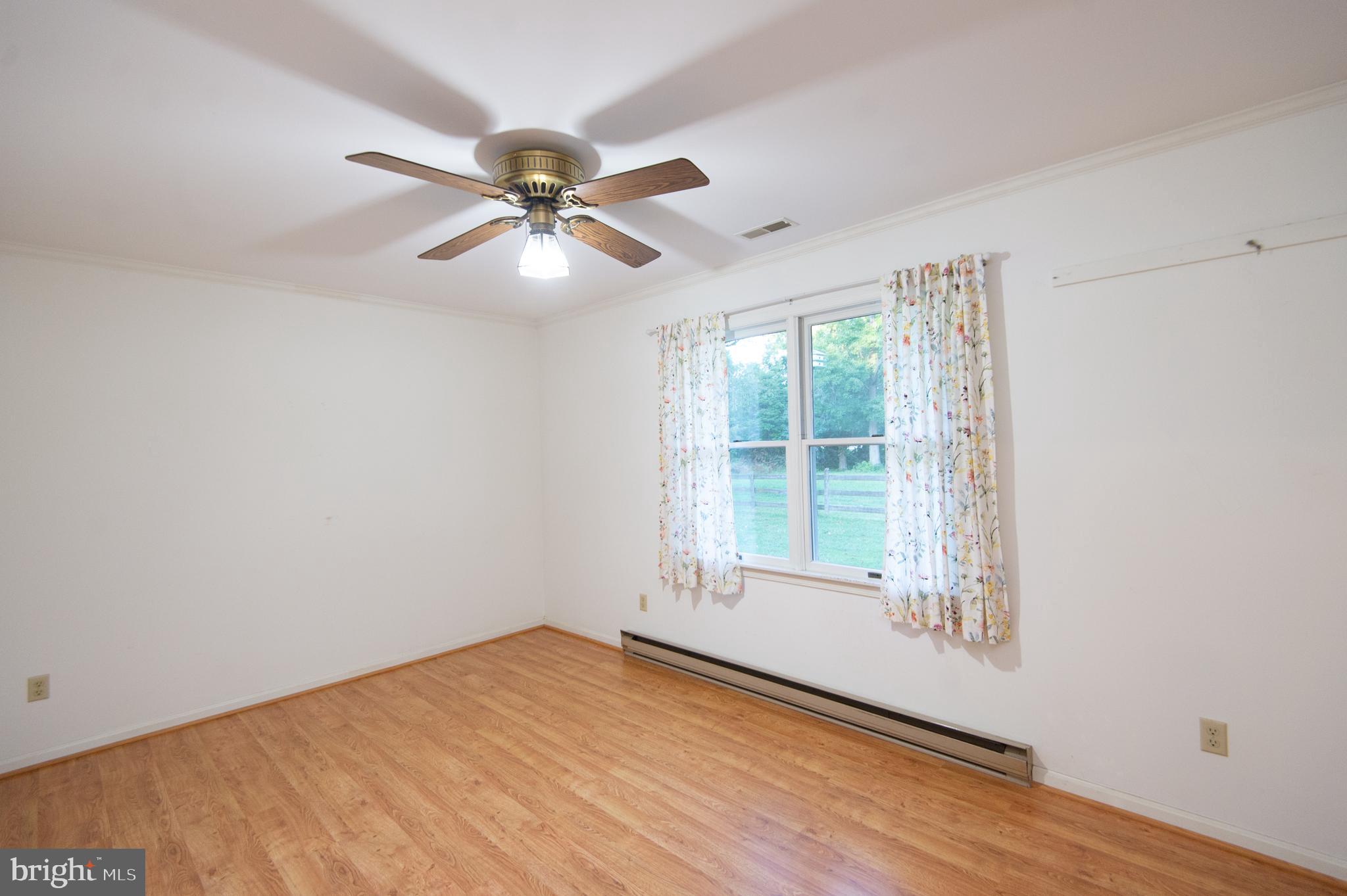 11482 Kittys Corner Road Cordova, MD 21625 - Photo 59 of 68 an empty room with wooden floor fan and windows