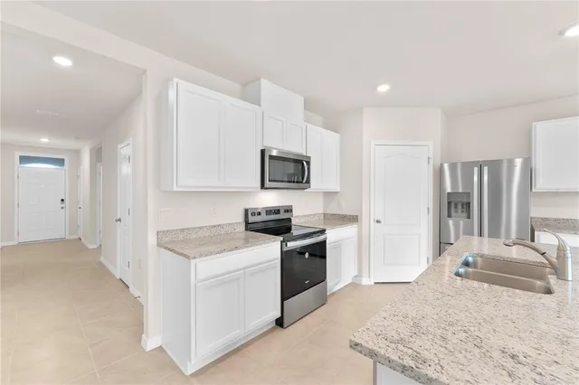 a kitchen with granite countertop a sink stove and refrigerator