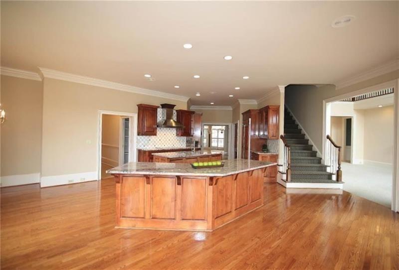 2737 Tarva Place Duluth, GA 30097 - Photo 4 of 33 a view of a kitchen with kitchen island wooden floor and stainless steel appliances