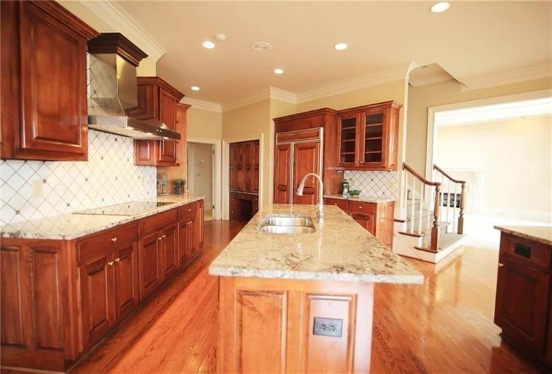 2737 Tarva Place Duluth, GA 30097 - Photo 5 of 33 a kitchen with stainless steel appliances kitchen island granite countertop a sink and cabinets