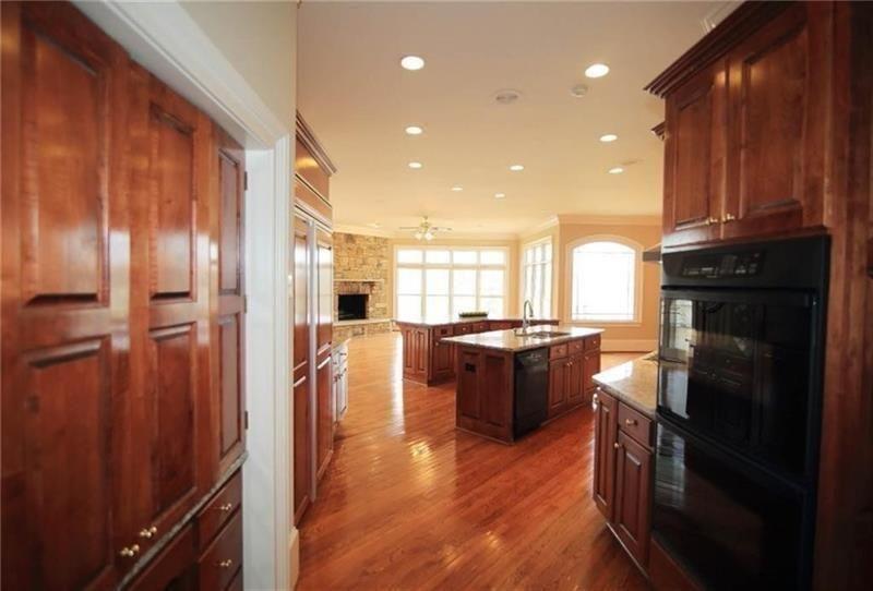 2737 Tarva Place Duluth, GA 30097 - Photo 8 of 33 a kitchen with stainless steel appliances granite countertop a refrigerator a sink dishwasher a stove and white countertops with wooden floor